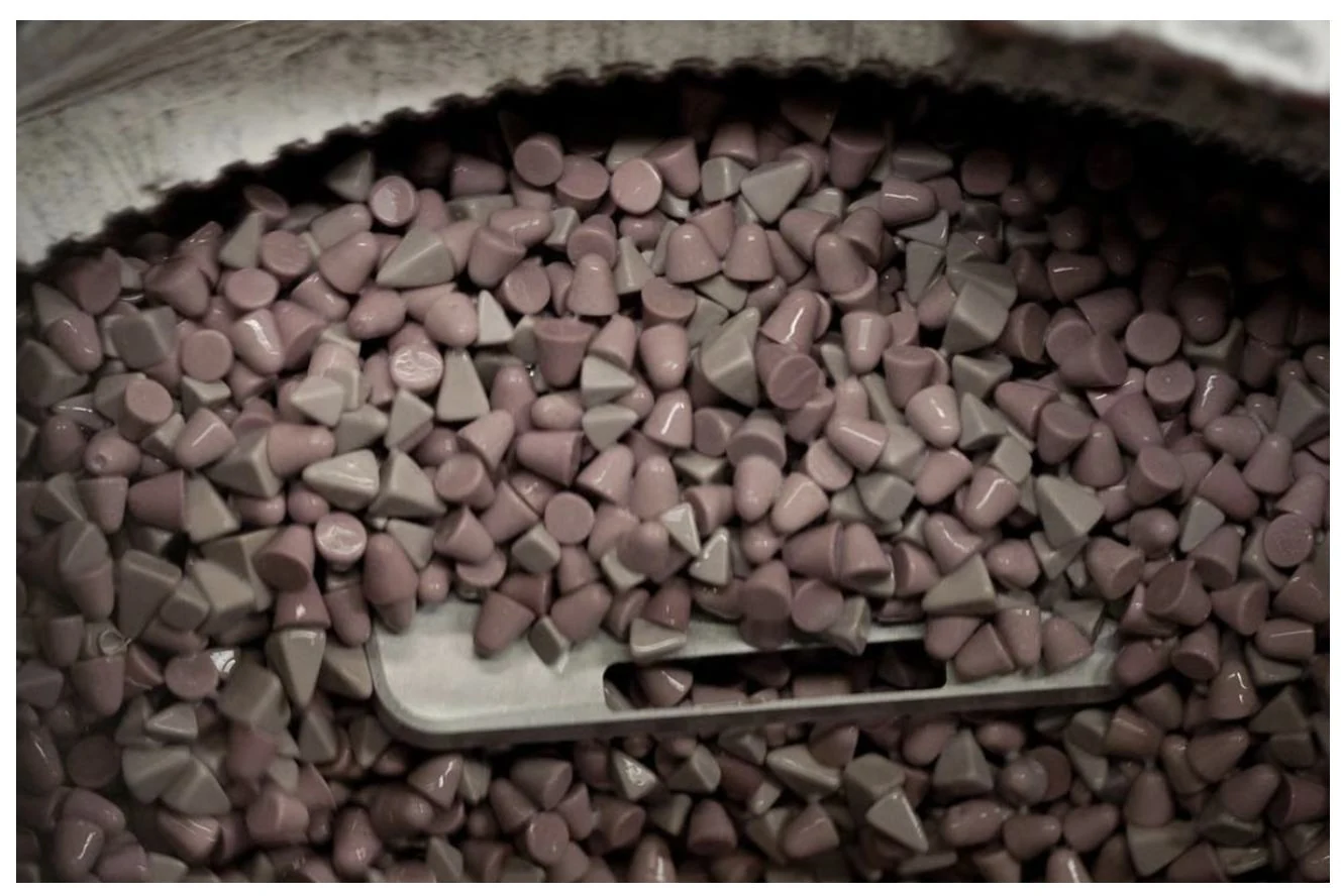A Grand EM aluminium chassis being tumble-deburred in ceramic media.