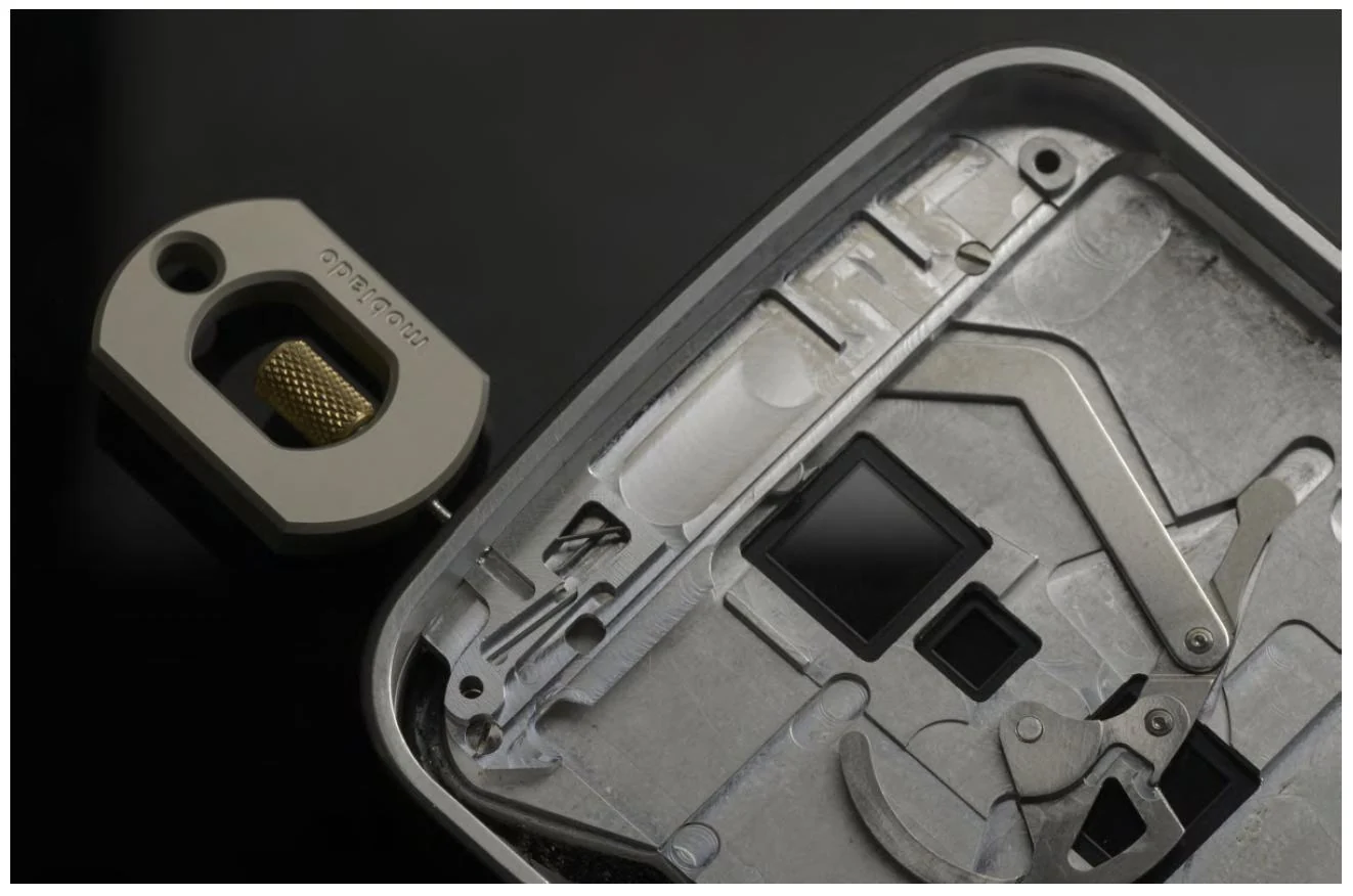 The exposed four-part cam mechanism and SIM opening key of Grand EM.