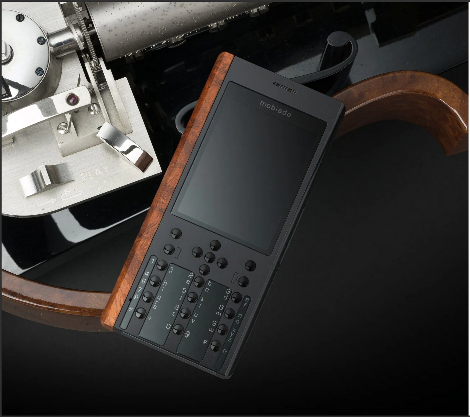 PRO3X with its Cocobolo grip, photographed beside a camera and leather strap.